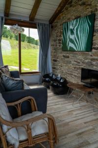 a living room with a blue couch and a stone wall at Complejo Rural Lar de Vies in A Pontenova