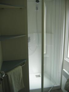 La salle de bains est pourvue d'une douche avec une porte en verre. dans l'établissement Camping du petit vaux Chez Camille, à Veynes