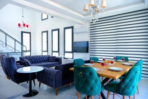 a dining room with a table and blue chairs at Villa OFELYA in Kas