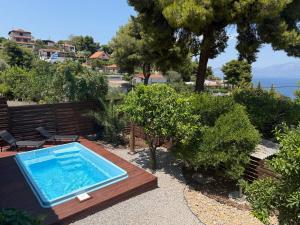 a swimming pool in the middle of a garden at Amara Blue Bay Villa in Kalamos