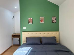 Ban Bung Maiมาแคมป์ ชะอม的一间卧室，配有一张床和绿色墙壁