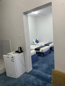 Cette chambre comprend deux lits et un réfrigérateur. dans l'établissement وحدات السيح الاقتصادية, à Médine