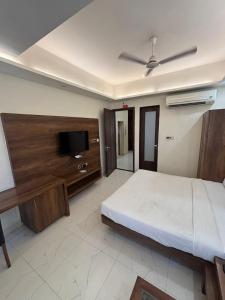 a bedroom with a bed and a flat screen tv at Hotel Ada Regency in Bhopal