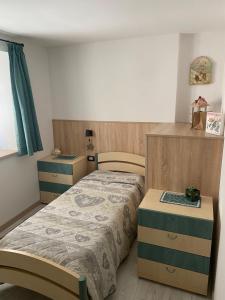 a small bedroom with a bed and a desk at tabià piz meda in Moena