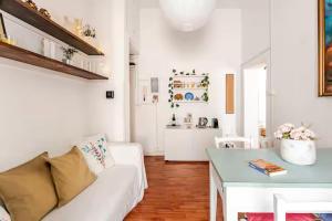 Una sala de estar con un sofá blanco y una mesa. en Casa della Salita San Pietro, en Roma