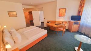 ein Hotelzimmer mit Bett und Schreibtisch in der Unterkunft Hotel Panorama Hamburg-Billstedt in Hamburg