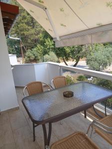 a table and chairs on the balcony of a house at Maria De luxe Apartment in Chrysi Ammoudia