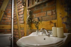 a bathroom with a sink and a brick wall at Cegiełka w Skarlance in Gaj Grzmięca