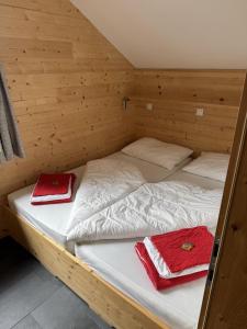 ザンクト・ガレンキルヒにあるZamangspitzhütte myRelaxs Ferienwohnung Alpenroseの赤いタオルが敷かれた木造の部屋のベッド