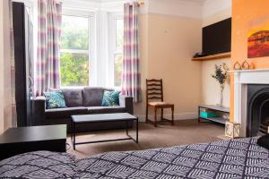 a living room with a bed and a couch and a fireplace at Thornbury Guest House Room 1 in Southampton