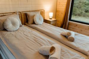 a bedroom with a bed with towels on it at Tiny House Sage - ElysianFields in Sadu