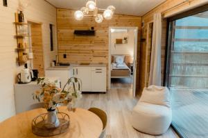 a kitchen and living room with a table and a couch at Tiny House Sage - ElysianFields in Sadu