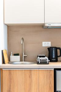 a kitchen counter with a sink and a microwave at Cozy Suite in Rhodes Town