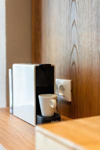 a coffee cup sitting on a counter next to a microwave at Cozy Suite in Rhodes Town +8 photos