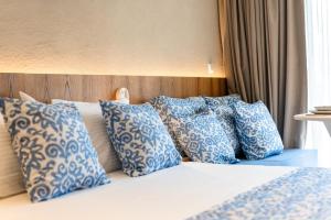 a bed with blue and white pillows on it at Cozy Suite in Rhodes Town