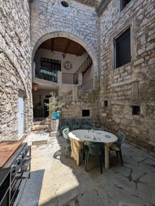 a patio with a table and chairs in a stone building at Chambres de Saint Alban in Saint Alban Auriolles