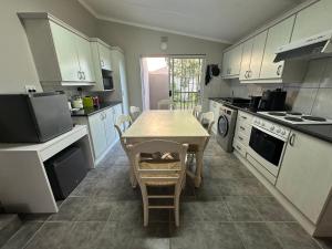 a kitchen with a table and a table and chairs at 82 on 21st in Mossel Bay +10 photos