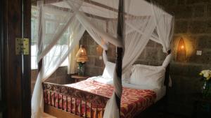 a bedroom with a canopy bed with white curtains at Woodmere Serviced Apartment in Nairobi