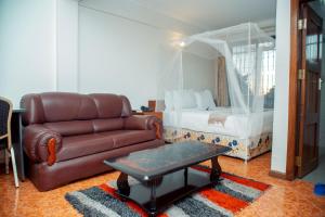 a living room with a couch and a bed at MBEYA PARADISE INN in Mbeya +81 photos