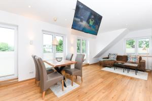 una sala da pranzo con tavolo, sedie e divano di Alte Molkerei a Esens