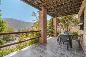 a patio with a table and chairs and a view at Las Gallinas Cottage Orgiva in Órgiva