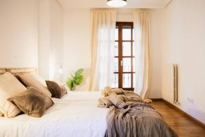 a large white bed in a room with a window at Casa Estébanes 2 BR Premium Familiar 7 Pax in Zaragoza