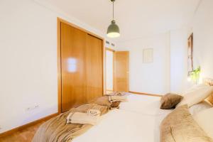 a bedroom with a large bed with white sheets at Casa Estébanes 2 BR Premium Familiar 7 Pax in Zaragoza