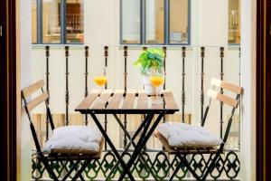 a table with two glasses of orange juice and two chairs at Casa Estébanes 2 BR Premium Familiar 7 Pax in Zaragoza