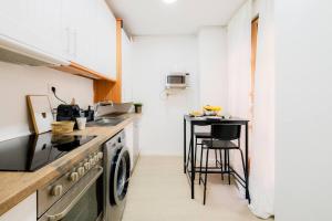 a small kitchen with a stove and a table at Casa Estébanes 2 BR Premium Familiar 7 Pax in Zaragoza +25 photos