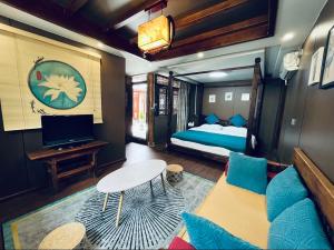 a bedroom with a bed and a table and a couch at Lewo Guest House in Lijiang