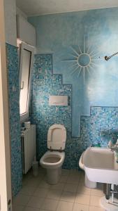 un bagno piastrellato blu con un water e un lavandino di danny a Cattolica