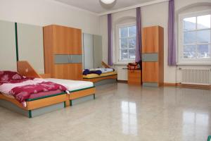 a bedroom with two beds and two windows at Bischöfliches Institut Vinzentinum in Bressanone