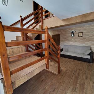 a living room with a staircase and a couch at Casa Diana in Curtea de Argeş
