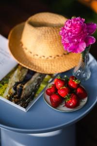 Un sombrero y un plato de fresas sobre una mesa. en Akacjowe Zacisze, en Stańkowa
