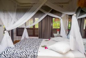 a bedroom with a zebra print bed with a canopy at Seb Villa in Diani Beach +36 photos