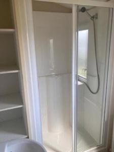 a shower with a glass door in a bathroom at Lovely 8 Berth Caravan For Hire In Essex At Naze Marine Park Ref 17181P in Walton-on-the-Naze