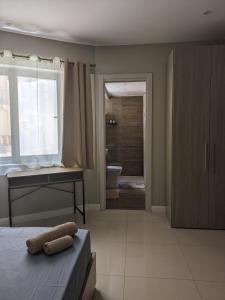 a bedroom with a bed and a desk and a bathroom at Salus Holiday Apartment in Victoria