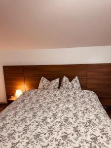 a bedroom with a bed with a wooden headboard and pillows at Casa cu Cires Breaza in Podu Vadului