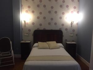 a bedroom with a bed with two night stands and two lights at Posada El Marqués De Trancadorio in La Virgen +6 photos