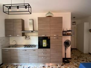 a kitchen with wooden cabinets and a stove top oven at Studio di Omero in Verona