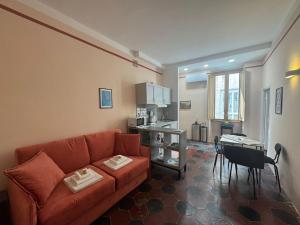 a living room with a red couch and a kitchen at Le Due Torri in Rione Monti in Rome