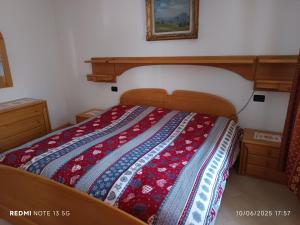 een bed met een quilt erop in een slaapkamer bij Casa Montagna in Canale San Bovo
