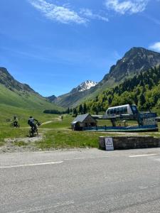 a man riding a bike on the side of a road at Studio cosy avec vue rivière et montagne in Barèges