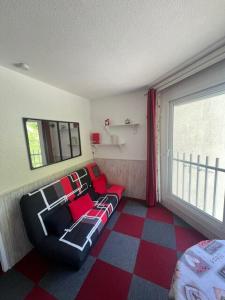 a living room with a couch and a window at Studio cosy avec vue rivière et montagne in Barèges