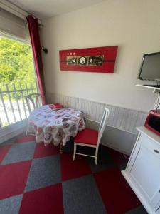 a small table and a chair in a room at Studio cosy avec vue rivière et montagne in Barèges