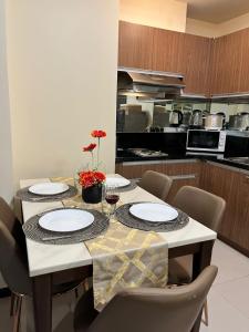 una cucina con tavolo, piatti e sedie di Cozy, aesthetic Pet friendly 1br Condo with balcony in Pasay with Manila Bay View Near MOA & Okada WFH ready Free Pool Acces Gym and Sauna a Manila