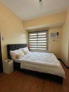 una camera da letto con un letto grande con una finestra di Cozy, aesthetic Pet friendly 1br Condo with balcony in Pasay with Manila Bay View Near MOA & Okada WFH ready Free Pool Acces Gym and Sauna a Manila