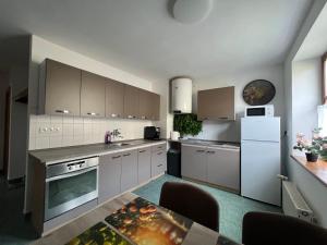 a kitchen with white cabinets and a white refrigerator at Apartmán 1 jar-leto in Martin