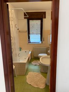 a bathroom with a tub and a toilet and a sink at Casa Bruna in Forno di Zoldo