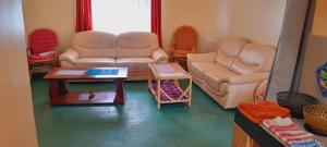 SekenaniManyatta Homestay的客厅里有一张沙发和一张桌子。